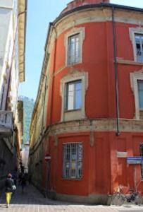 un edificio anaranjado en una calle con gente pasando por delante en B&B Volta en Como