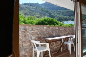 - Balcón con mesa y sillas y pared de piedra en La Orospeda, en Cazorla