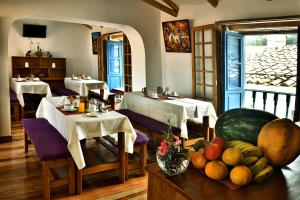 a restaurant with two tables and a bowl of fruit at Amaru Colonial in Cusco