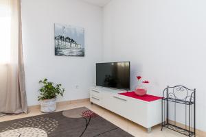 a living room with a tv on a white cabinet at APARTMENT JURAŠIN in Kaštela