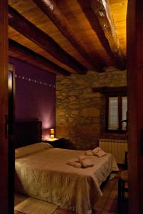 a bedroom with a large bed in a stone wall at Casa Cal Pastor in Salo