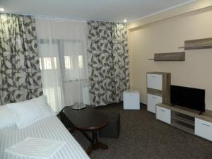 ein Hotelzimmer mit Bett und Fernseher in der Unterkunft Liador in Câmpia Turzii