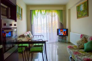 a living room with a table and a couch and a television at Apartment nearby Golden Coast in Protaras