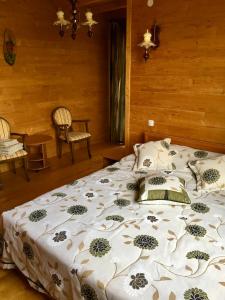 una camera da letto con un grande letto con un copriletto floreale di Girska Khatynka a Slavske