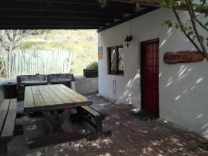 een picknicktafel buiten een huis met een rode deur bij Masescha Country Estate in Plettenbergbaai