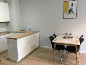 ウストロニエ・モルスキエにあるApartament Słoneczny Dwie Sosnyのキッチン(テーブル、テーブル、椅子付)