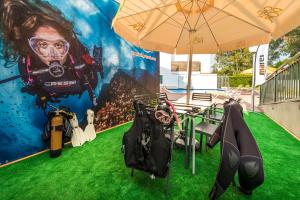 a table with an umbrella and some green grass at Apartaments Els Llorers in Lloret de Mar