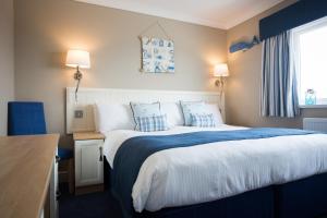 a bedroom with a large bed with blue and white sheets at Hotel Sheraton in Blackpool
