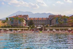 a group of people on a beach near a body of water at Fame Residence Kemer & Spa in Kemer