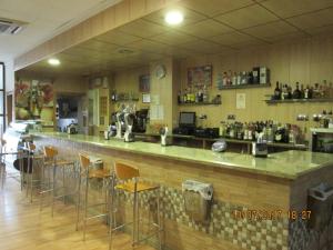 a bar in a restaurant with bar stools at Hostal Banderas in Fuensanta de Martos