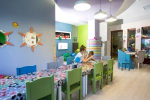 a woman and child sitting at a table in a room at Fame Residence Kemer & Spa in Kemer