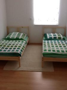 バート・クロイツナハにあるApartment Alexander Bad Kreuznachのベッド2台が隣同士に設置された部屋です。