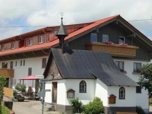 a small white church with a black roof at Weixler Schindelberg in Oberstaufen