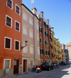 a row of colorful buildings on a street at Ca' Zuliani Rooms in Chioggia