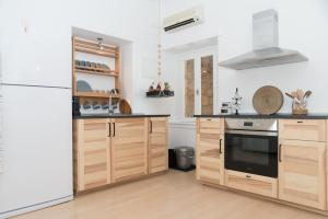 a kitchen with wooden cabinets and a white refrigerator at Aretousa Deluxe Downtown Apartment in Skala