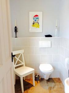 a white bathroom with a toilet and a chair at Holland House in Ballyshannon