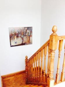 een houten trap met een foto aan de muur bij Holland House in Ballyshannon