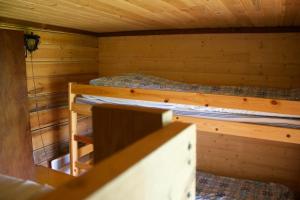 MoksinkyläにあるSurkeenjärvi Traditional Aittaのキャビン内のベッドルーム1室(二段ベッド2組付)