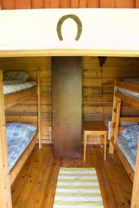 MoksinkyläにあるSurkeenjärvi Traditional Aittaの二段ベッド2台とテーブルが備わる客室です。