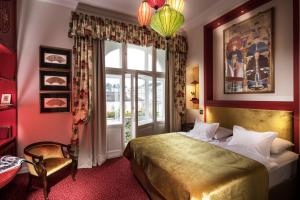 a bedroom with a bed and a large window at Hotel Bristol Salzburg in Salzburg +47 photos