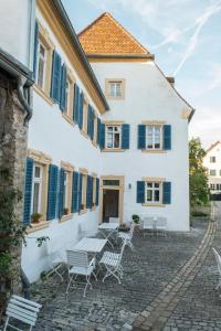 a white building with blue shutters and tables and chairs at Villa Sommerach in Sommerach