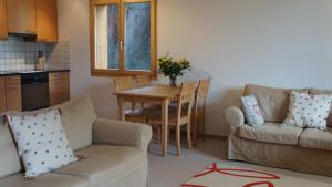 a living room with a table and a couch and a kitchen at Roossi-Huus 2 in Wengen +6 photos