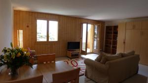 a living room with a couch and a table at Roossi-Huus 2 in Wengen