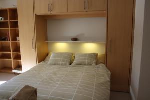 a bedroom with a bed with pillows and cabinets at Roossi-Huus 2 in Wengen