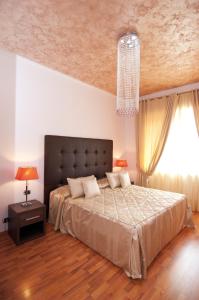 Un dormitorio con una cama grande y una lámpara de araña. en Complesso Termale Vescine, en Castelforte