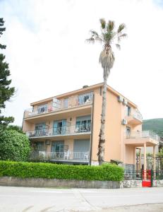 a building with a palm tree in front of it at Sea Star Danica apartments in Tivat