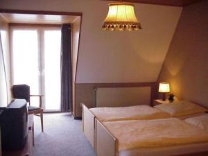 a hotel room with two beds and a chandelier at Hotel Tivoli in Osterholz-Scharmbeck