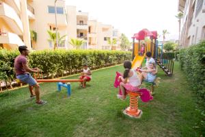 a group of children playing on a playground at Fame Residence Kemer & Spa in Kemer