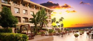 a hotel patio with tables and chairs at sunset at Fame Residence Kemer & Spa in Kemer