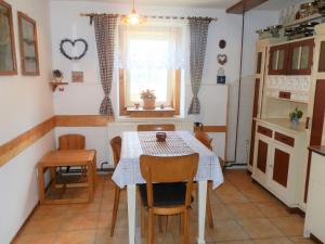 cocina con mesa, sillas y ventana en Chalupa Medium, en Krásná Lípa