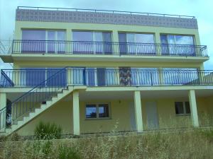 a yellow building with blue balconies and stairs on it at Villa Ortiga in Mação