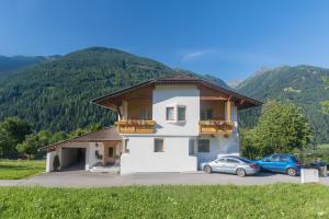 a building with two cars parked in a parking lot at Haus Fuetsch in Virgen