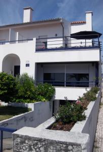 a white house with a balcony and some bushes at Villa Spozendus in Esposende