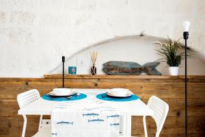 stół z 2 krzesłami i biały stół z niebieskimi płytami w obiekcie Borgo Albergo Capozzi 37 w mieście Monopoli