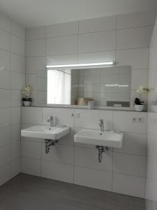 a bathroom with two sinks and a mirror at Apartment by Janzen in Rheine