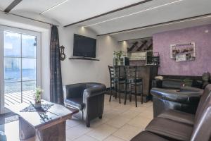 a living room with a bar with chairs and a tv at Sachsenbucherhof in Gurten