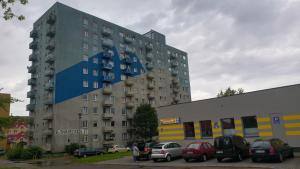 a large building with cars parked in a parking lot at Apartament u Teofila in Koszalin