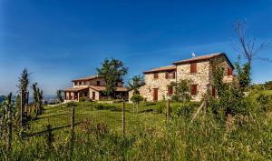 an old stone house on a hill in a field at Agriturismo Eutopia in San Leo