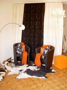 ClarensにあるCharming Studio with Balcony | 71の- リビングルーム(黒い椅子2脚、オレンジ色の枕付)