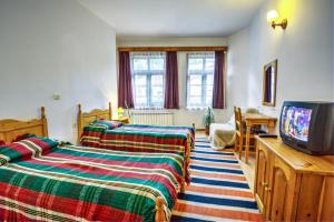 ein Schlafzimmer mit 2 Betten und einem TV. in der Unterkunft Hotel Kalina in Shiroka Lŭka
