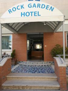 un edificio de hotel con jardín de rocas con un cartel en él en Rock Garden, en Gaeta