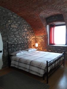 una camera da letto con un letto in un muro di mattoni di La Maison Rose CIR 0244 ad Aosta