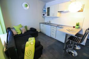 a kitchen and a living room with a couch and a table at Apartments Lavanda in Primošten