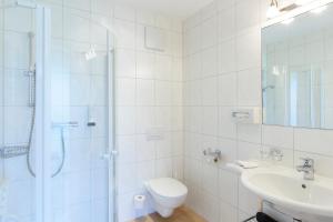 a bathroom with a shower and a toilet and a sink at Hotel Silbertal in Silbertal