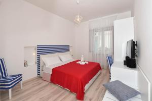 - une chambre avec un lit rouge et une télévision dans l'établissement CDA Apartament, à Minori