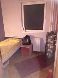 a small bedroom with a bed and a window at Apart Oggie in Skopje